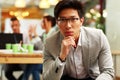 Pensive asian man sitting in office