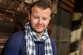 Pensive attractive man leaning against wooden wall