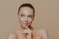 Pensive attractive young European woman with white healthy skin, looks aside, has naked body, undergoes beauty treatments, poses Royalty Free Stock Photo