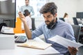 Pensive bearded business man with paper document and pen reading some notes in the notebook at office Royalty Free Stock Photo