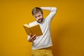 Pensive bearded man holds in hands a book that he has read to the middle and is now experiencing contradictions.