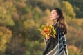 Pensive beautiful girl with bouquet of autumn leaves. Portrait of young brunette woman Royalty Free Stock Photo