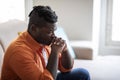 Pensive black man sitting on couch at home, copy space Royalty Free Stock Photo