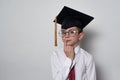 Pensive boy in academic hat and glasses on a white background. Kid education Royalty Free Stock Photo