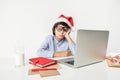 Pensive boy in christmas hat is feeling weary