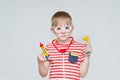 Pensive boy playing doctor. Toy syringe, glasses and phonendoscope. Portrait Royalty Free Stock Photo