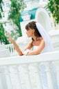 Pensive bride in a white dress looks at manicure Royalty Free Stock Photo