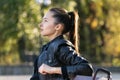 Pensive brunette girl outdoors portrait. Resting in the park. Side view