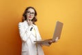 pensive business girl in glasses and suit uses laptop on colored background, woman manager works at computer Royalty Free Stock Photo