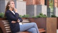 Pensive Business Woman Thinking while Sitting Outside Office on Bench Royalty Free Stock Photo