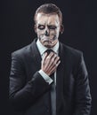 Pensive businessman with makeup skeleton