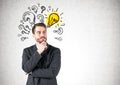 Pensive businessman, question marks and lightbulb Royalty Free Stock Photo