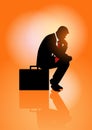 Pensive businessman sitting on his briefcase