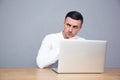 Pensive businessman sitting at the table with laptop Royalty Free Stock Photo