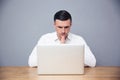 Pensive businessman sitting at the table and using laptop Royalty Free Stock Photo