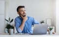 Pensive businessman sitting at workplace in modern office, thinking about business idea Royalty Free Stock Photo