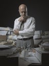 Pensive businessman surrounded by paperwork Royalty Free Stock Photo