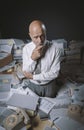 Pensive businessman surrounded by paperwork Royalty Free Stock Photo