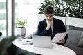 Pensive businessman work on laptop with paper documents Royalty Free Stock Photo