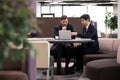 Pensive businessmen cooperate on laptop in office