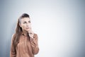 Pensive businesswoman, gray wall Royalty Free Stock Photo