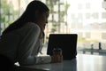 Pensive businesswoman holding coffee cup and looking away while sitting at workplace. Royalty Free Stock Photo