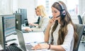 Pensive businesswoman talking on headset while working on laptop in office. Royalty Free Stock Photo