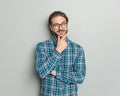 pensive casual man in plaid shirt with glasses folding arms and thinking Royalty Free Stock Photo