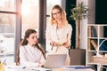 Pensive caucasian businesswomen in formalwear talking while working at modern office