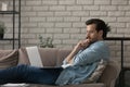 Pensive Caucasian man work on laptop at home thinking Royalty Free Stock Photo