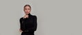 Pensive caucasian young woman wearing black turtleneck holding finger near her face, looking thoughful aside, standing Royalty Free Stock Photo