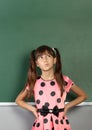 Pensive child girl near blank school blackboard