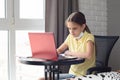 Pensive child sitting at the table taking off a medical mask and doing homework Royalty Free Stock Photo