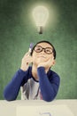 Pensive clever boy under light bulb Royalty Free Stock Photo