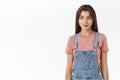 Pensive and creative good-looking woman in dungarees, t-shirt, have interesting idea on mind, looking left and smirk