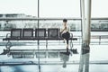 Black girl in waiting room of railway station with smartphone Royalty Free Stock Photo