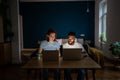 Pensive diverse couple of freelancers working online together late at night