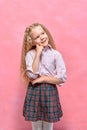 Pensive dreaming little girl schoolgirl. pink background