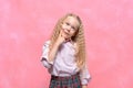 Pensive dreaming little girl schoolgirl. pink background