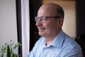 Pensive elderly mature senior man in eyeglasses looking in distance out of window, thinking. Royalty Free Stock Photo