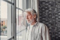 Pensive elderly mature senior man in eyeglasses looking in distance out of window, thinking of personal problems. Lost in thoughts Royalty Free Stock Photo