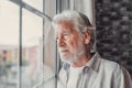 Pensive elderly mature senior man in eyeglasses looking in distance out of window, thinking of personal problems. Lost in thoughts Royalty Free Stock Photo