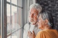 Pensive elderly mature senior man in eyeglasses looking in distance out of window, thinking of personal problems. Old woman wife Royalty Free Stock Photo