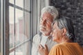 Pensive elderly mature senior man in eyeglasses looking in distance out of window, thinking of personal problems. Old woman wife Royalty Free Stock Photo