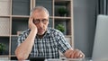 Pensive elderly 70s business man having financial problem working workplace workaholism overworked