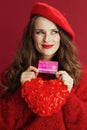 pensive elegant woman in red sweater and beret with red heart Royalty Free Stock Photo