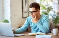 Pensive ethnic man using laptop at home