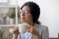 Pensive female in glasses drink coffee thinking or planning