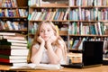 Pensive female student in library