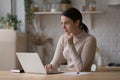 Pensive freelance worker working at laptop on kitchen table Royalty Free Stock Photo